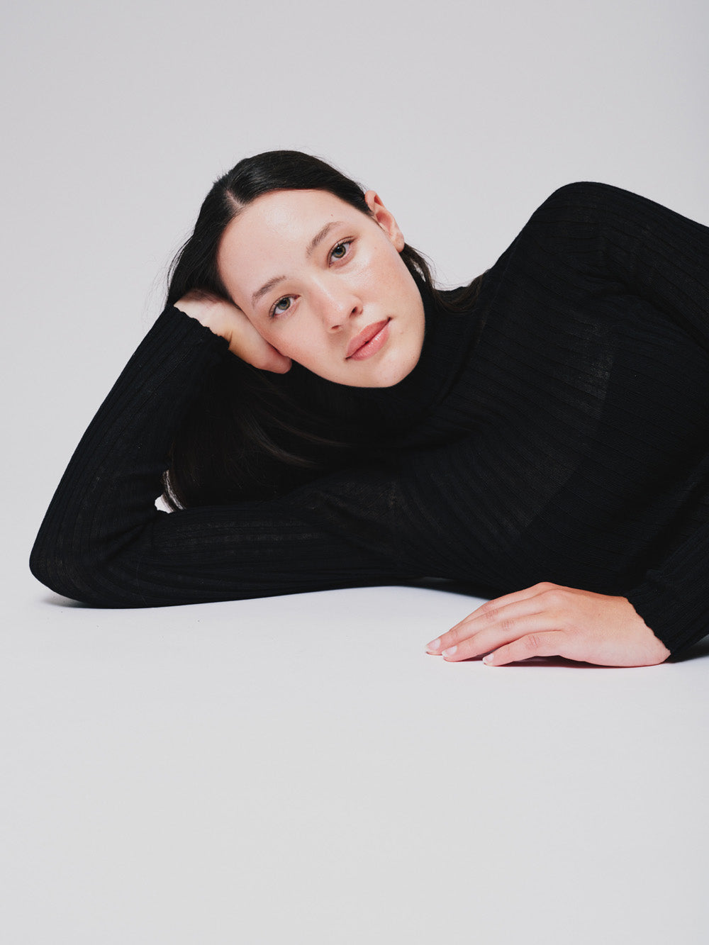 Woman wearing a sheer black tulle against a white background