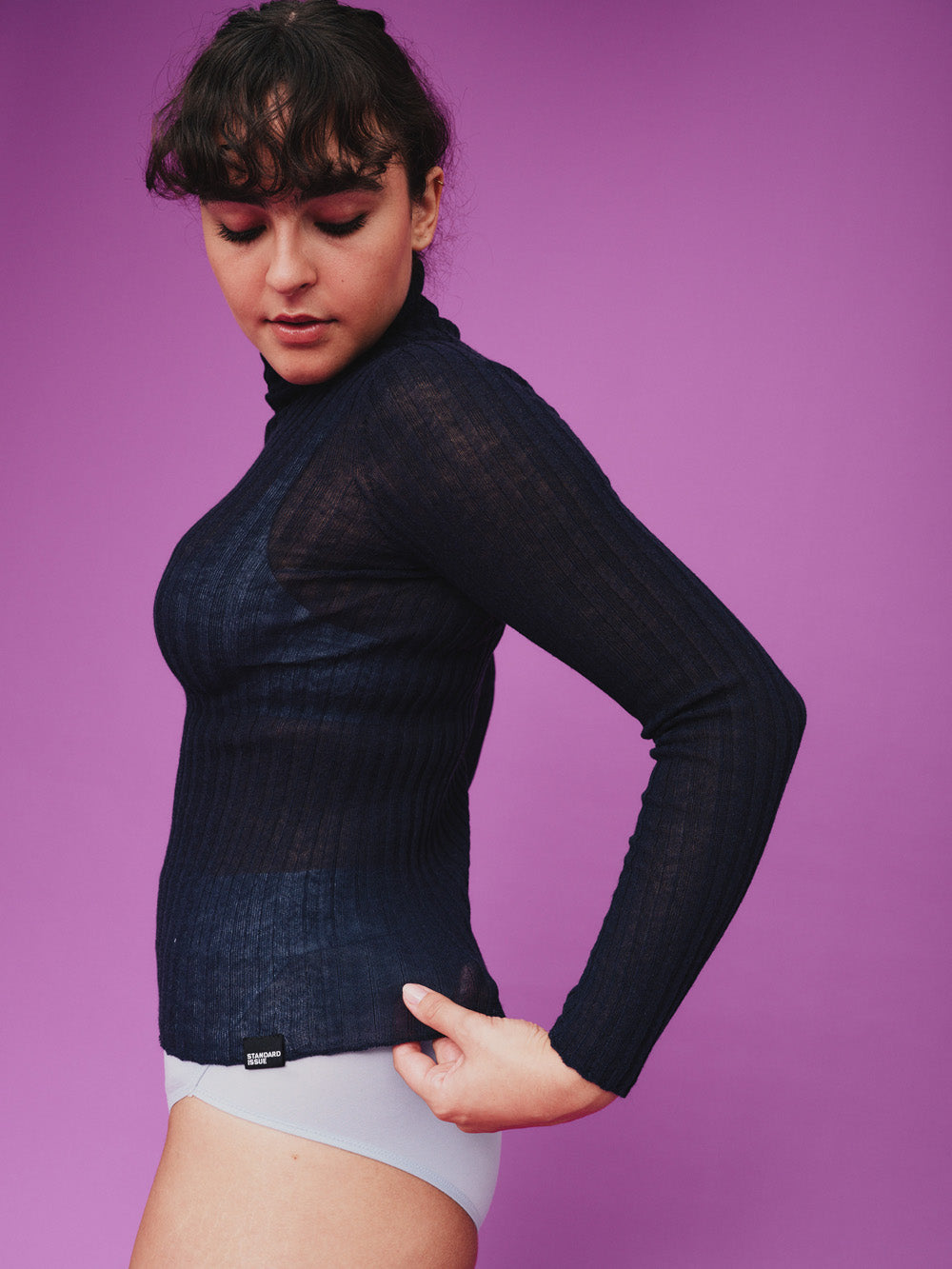 Woman wearing a sheer navy tulle against a purple background