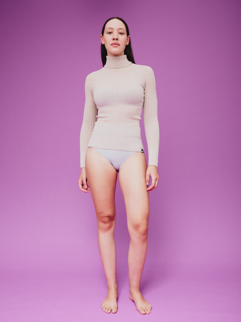 Woman wearing a sheer pearl white tulle against a purple background