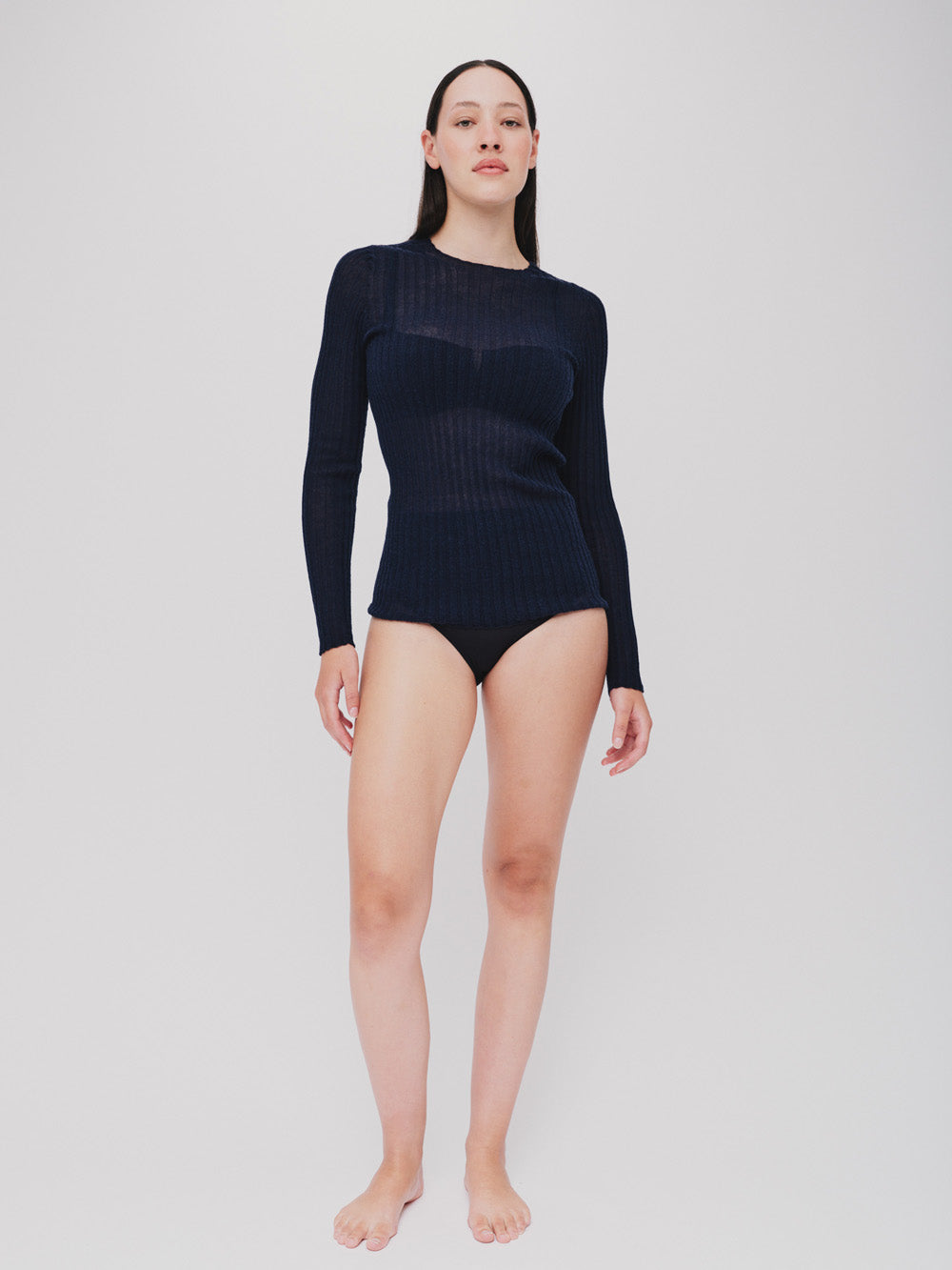 Woman wearing a navy ribbed merino tulle on a white background