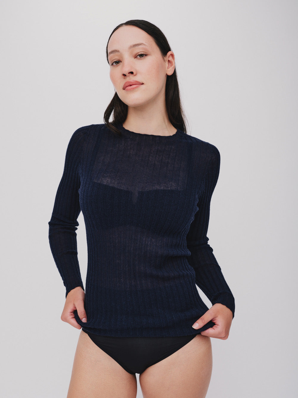 Woman wearing a navy ribbed merino tulle on a white background