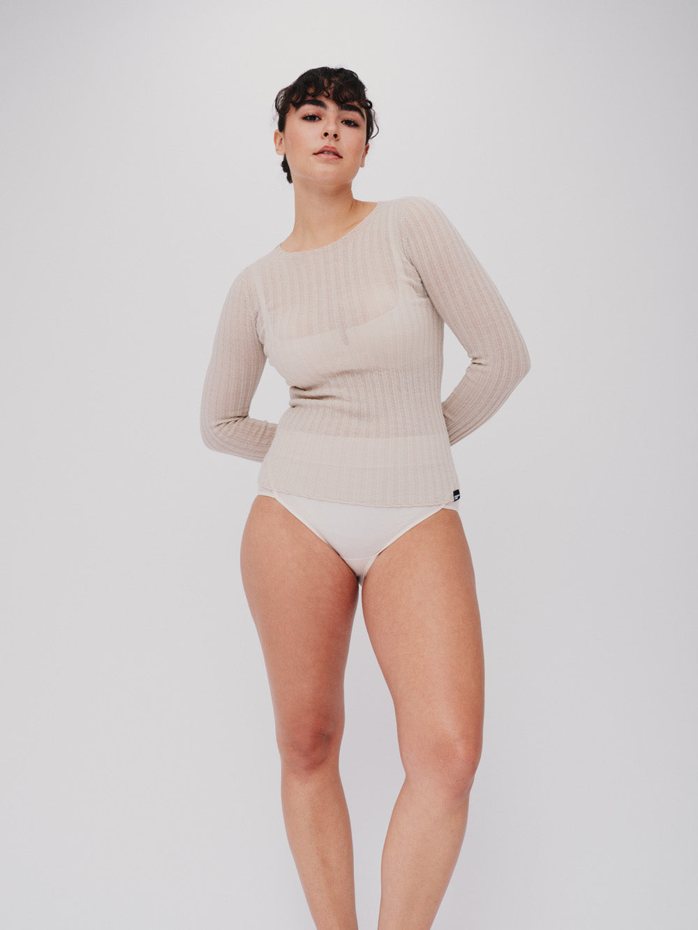 Woman wearing a pearl white ribbed merino tulle on a white background