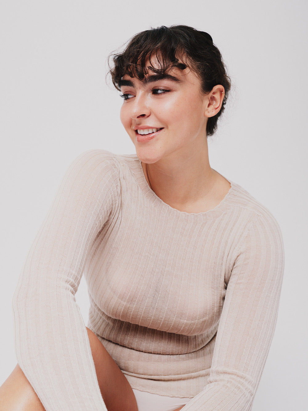 Woman wearing a pearl white ribbed merino tulle on a white background