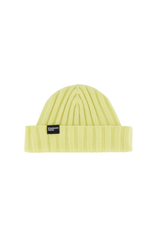 Yellow cashmere beanie with a brand label on a white background