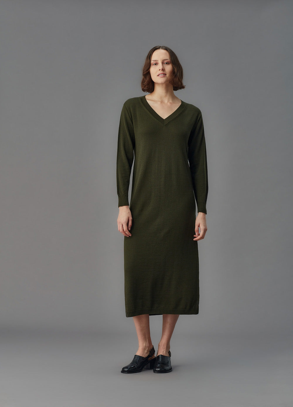 Woman wearing a green dress against a gray background