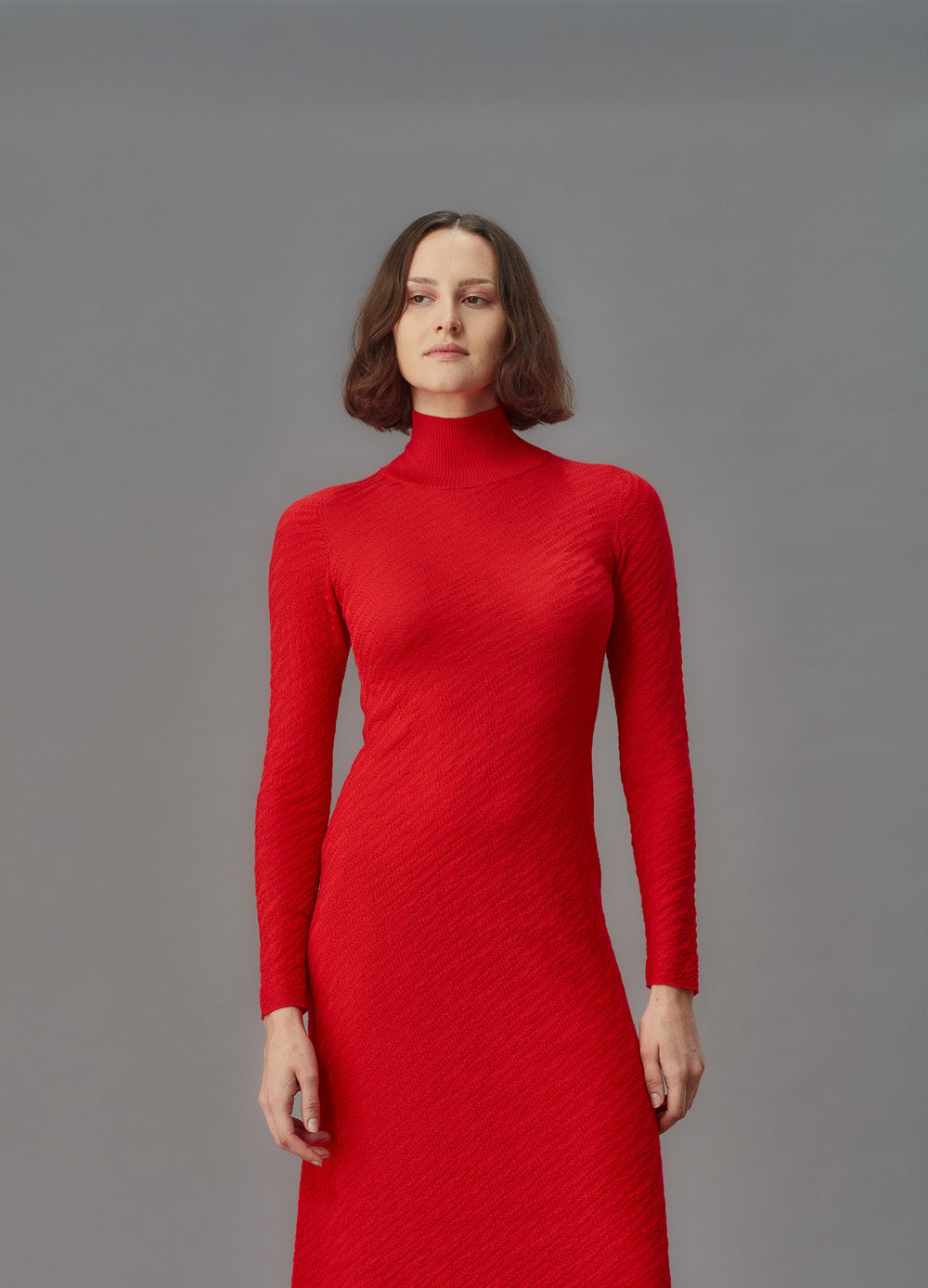 Woman wearing a red dress against a gray background