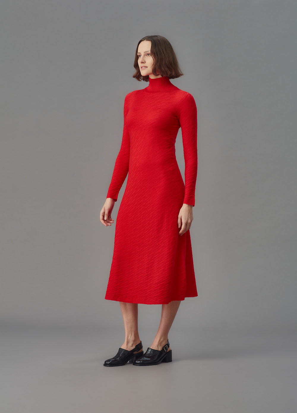 Woman wearing a red dress against a gray background