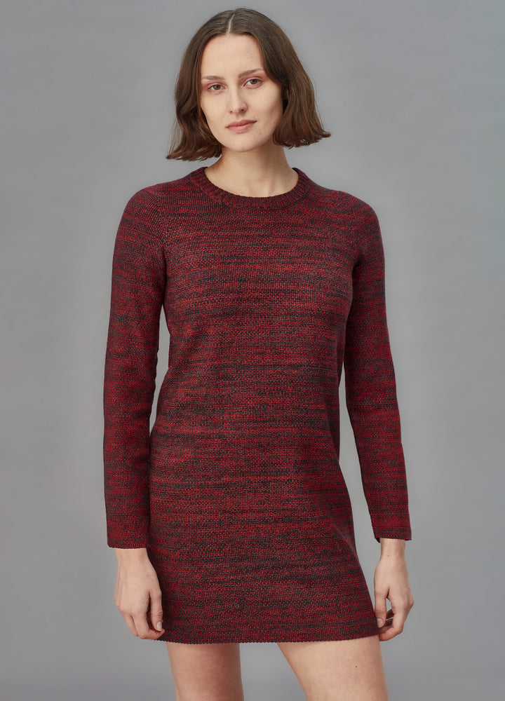 Woman wearing a red and black patterned dress against a gray background