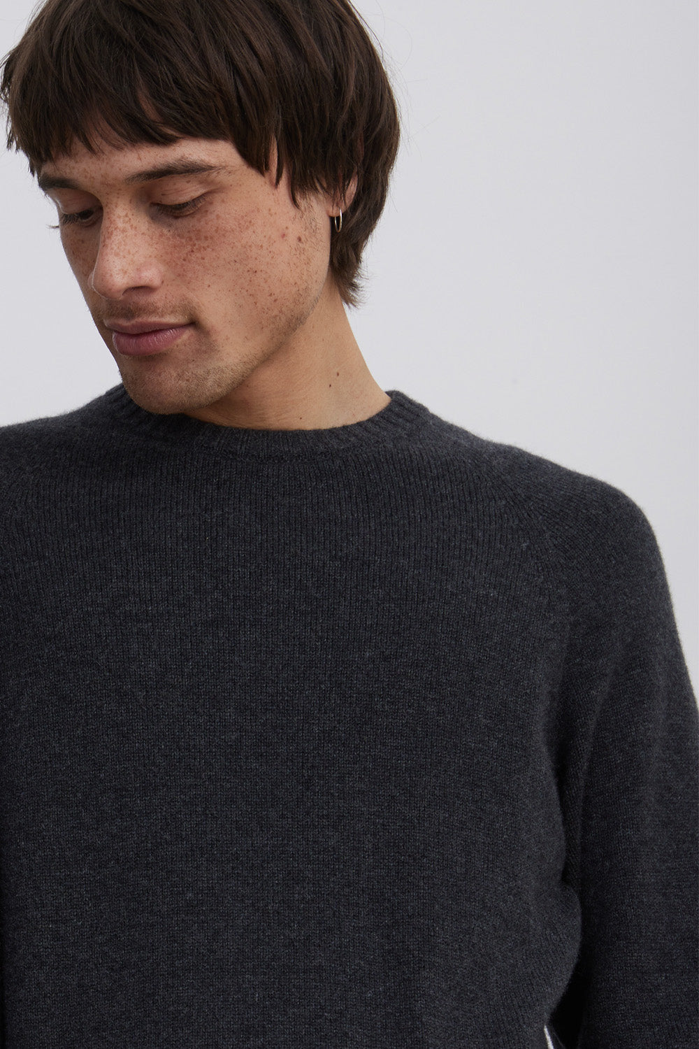 Man looking down wearing carbon colour jumper