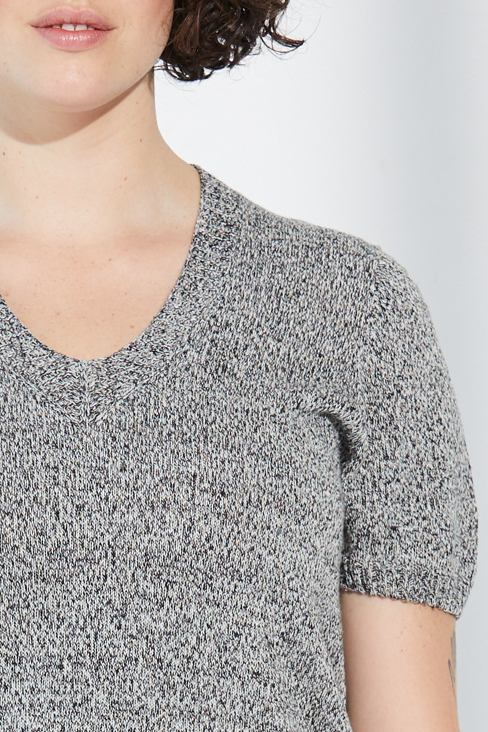 A close up of a woman wearing a twist-coloured Standard Issue Linen Tee.