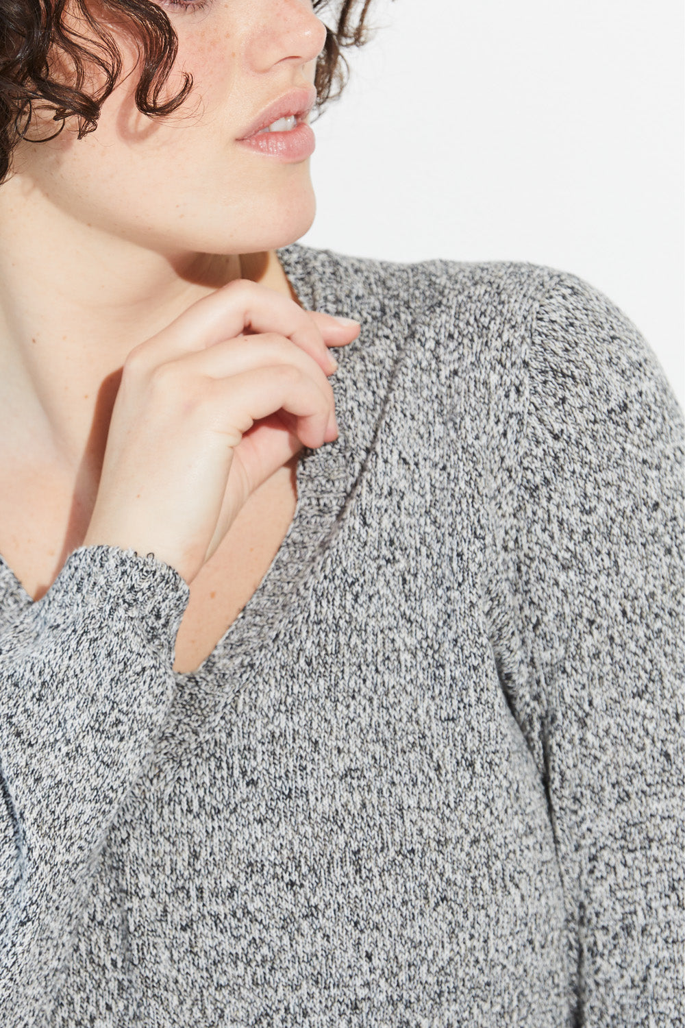 A close up of a woman wearing a twist-coloured Standard Issue Linen V jumper.