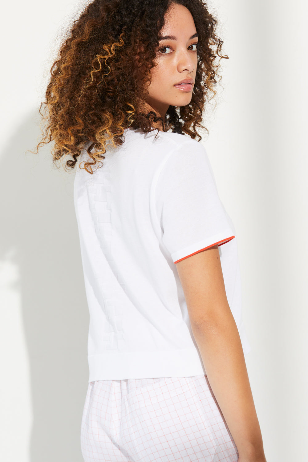 Woman wearing Standard Issue Cotton Boxy Tee in White and Flame colours.