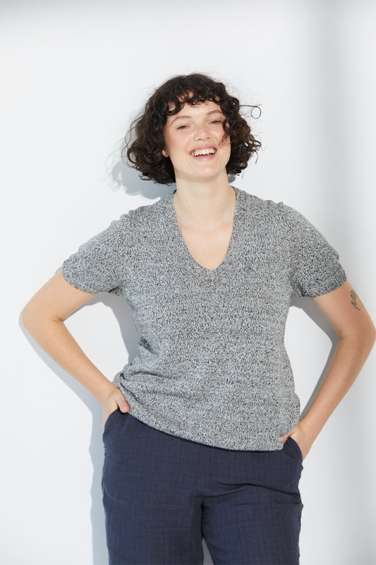 A woman smiling wearing a twist-coloured Standard Issue Linen Tee.